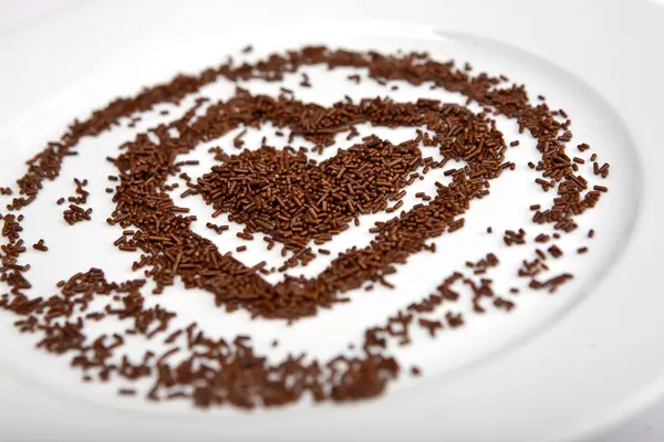 Heart of chocolate chips on a white plate porcelain — Stock Photo, Image