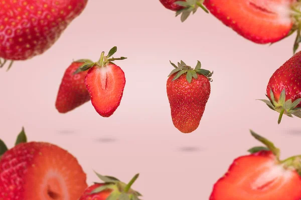 Creatief Idee Met Zwevende Zwevende Rijpe Aardbeien Een Pastelroze Achtergrond — Stockfoto