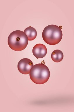 Pembe Noel mücevherleri. Havada uçuşan süsler. İyi tatiller. Yeni yıl konsepti çok az. Noel asgari fikri.
