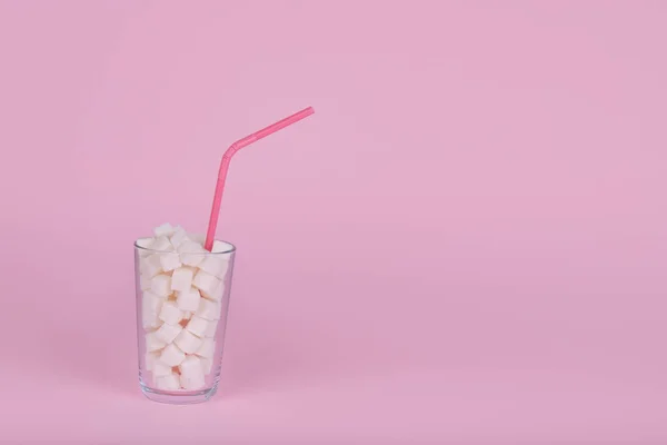 Szklanka Pełna Kostek Cukru Słomką Pastelowym Różowym Tle Niezdrowa Koncepcja — Zdjęcie stockowe