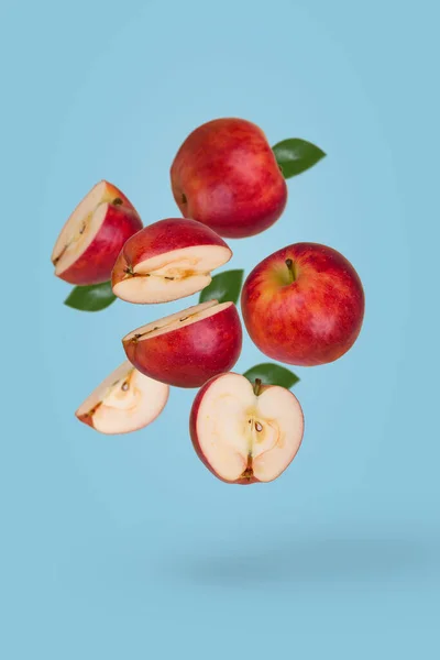 最小的水果概念与新鲜切片和整个苹果漂浮在空气中隔离的蓝色背景 维生素 健康饮食的概念 有飞果的创意概念 — 图库照片