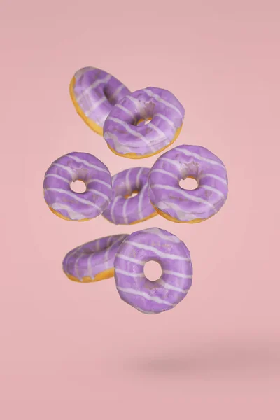 Фіолетові Прикрашені Пончики Русі Падають Або Літають Рожевому Фоні Мінімальний — стокове фото