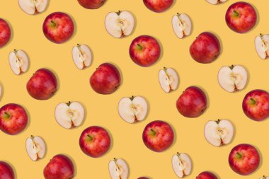 Taze elma deseni ve pastel sarısı arka planda yarımlar. Minimalist izometrik sağlıklı gıda konsepti. Düz yatıyordu