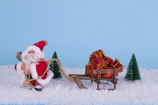 Kreative Weihnachtskomposition Mit Weihnachtsmann Schnee Und Schlitten Mit Vielen Geschenken — Stockfoto