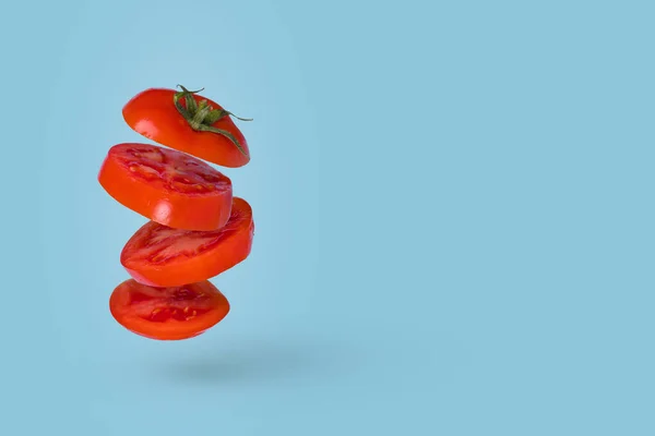 切碎的西红柿在空气中飘扬 被明亮的蓝色背景隔离 生素食健康饮食配料 创意食品概念 复制空间 — 图库照片