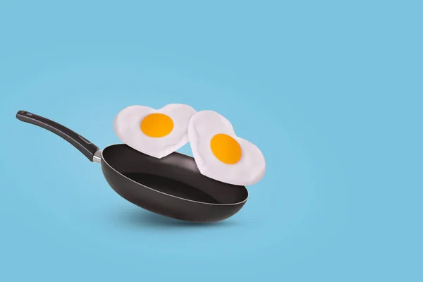 创意与一个煎锅和两个煎蛋的心脏形状在明亮的蓝色背景 最小的食物和爱的概念 情人节的早餐想法和浪漫的早晨 复制空间 — 图库照片