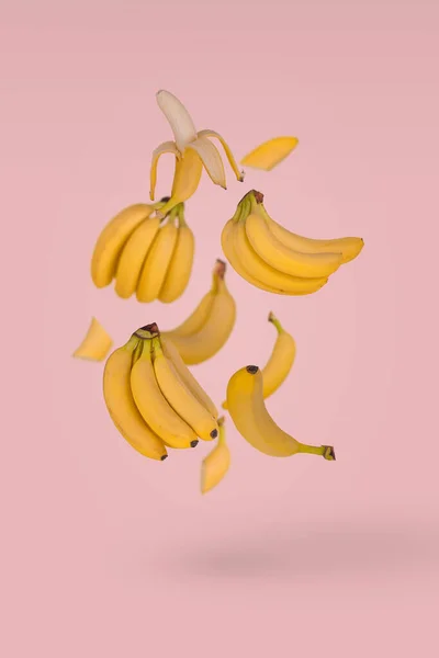 Sacco Banane Fresche Che Volano Aria Isolate Uno Sfondo Rosa — Foto Stock