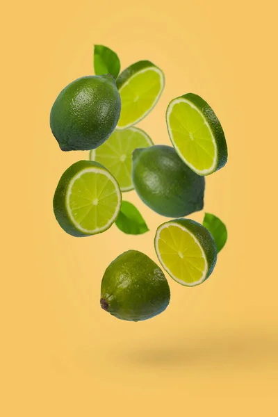 Kreativ Idé Med Hela Och Skivad Lime Flyger Luften Isolerad — Stockfoto
