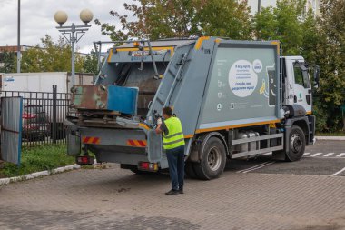 M. Lunna Caddesi, Balashikha, Rusya 04 Nisan 2020. Çöp toplama servisi, çöp temizleyici üniformalı adam çöp boşaltmak için kamyon yükleme işiyle uğraşıyor. Geri dönüşüm kavramı.