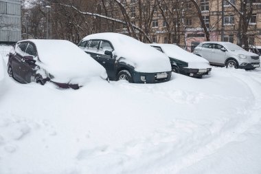 Arabalar karda duruyor. Arabada kar yağışı var. Şiddetli kar yağışı karla kaplı arabalar. Karla kaplı arabalar..