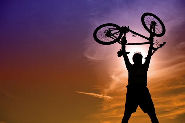 Mountain biker with bike over dramatic sky — Stock Photo, Image