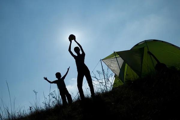 Familie camping. silhouet van moeder en zoon plezier buiten in de buurt van tent. herfst zomer outdoor activiteit concept. toerisme concept — Stockfoto