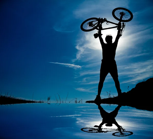 Silhouette of a man with a bike — Stock Photo, Image