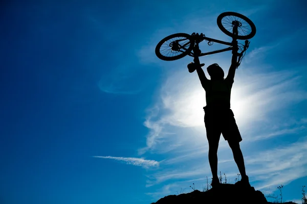 Silhuetten av en man med en cykel — Stockfoto