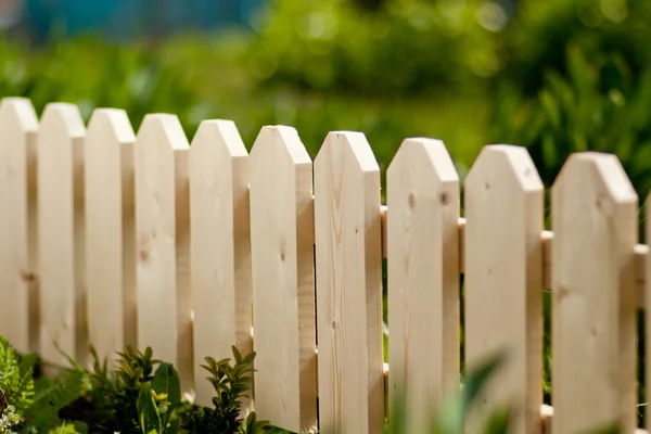 Détail d'une clôture de jardin en bois avec de l'herbe verte en arrière-plan. Lumière du jour — Photo