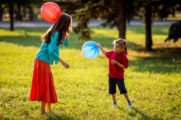 Mère et fils s'amusent dans le parc printanier en mouvement. rétro-éclairé. se concentrer sur la mère — Photo