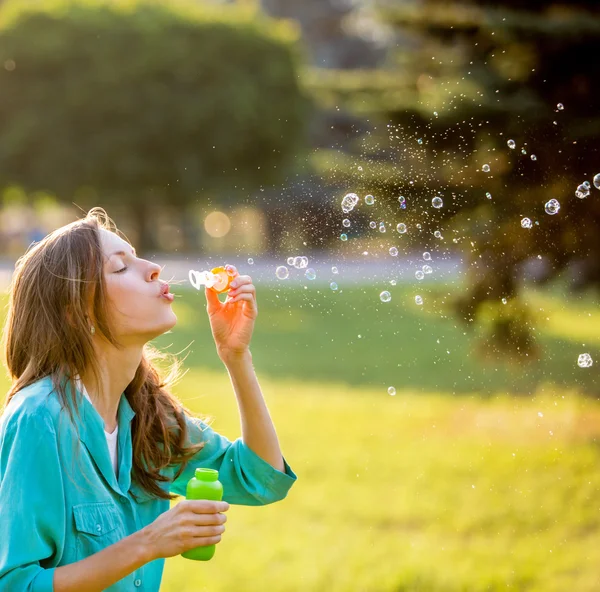 Beautiful woman blowing bubbles — Stock Photo, Image