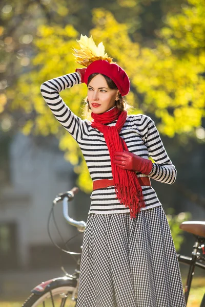 Mulher elegante bonita de pé em um parque no outono e segurando folhas de outono. Cena urbana. estilo de vida — Fotografia de Stock