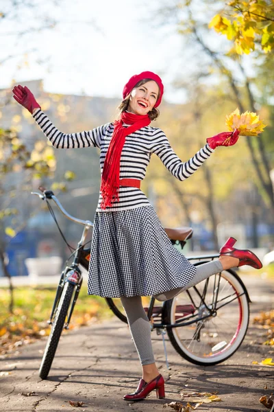 Beautiful woman with bike in autumn park having fun. Hollywood style — Stock Photo, Image