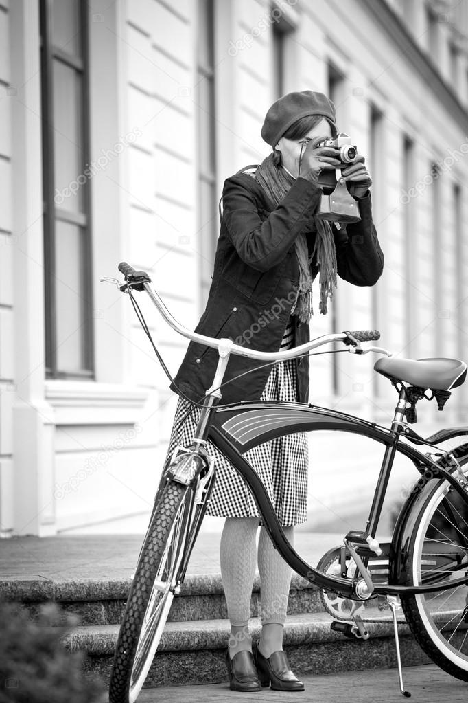 Girl with retro camera and city bike. Urban life. black and white Stock