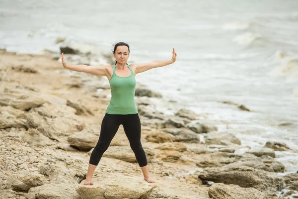 Pretty woman doing yoga near sea — Stock Photo, Image