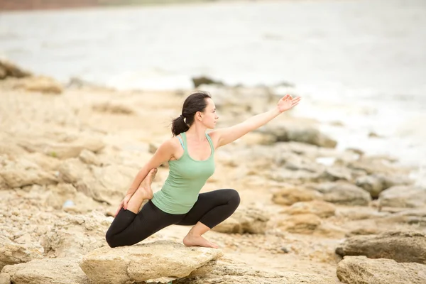 Pretty woman doing yoga near sea — Stock Photo, Image