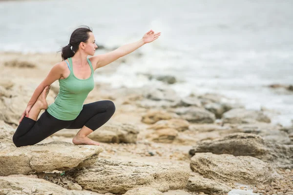 Pretty woman doing yoga near sea — Stock Photo, Image