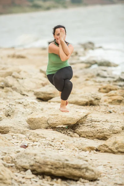 Pretty woman doing yoga near sea — Stock Photo, Image