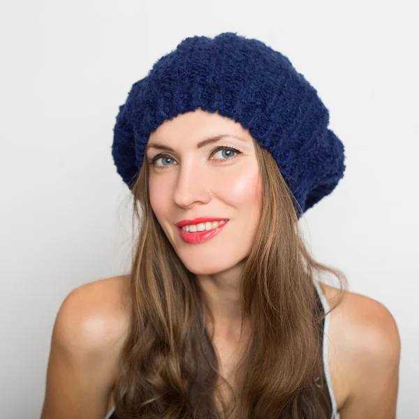 Portrét smějící se mladé ženy v pletené čepici — Stock fotografie