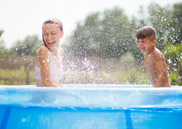 Familia divirtiéndose en una piscina — Foto de Stock