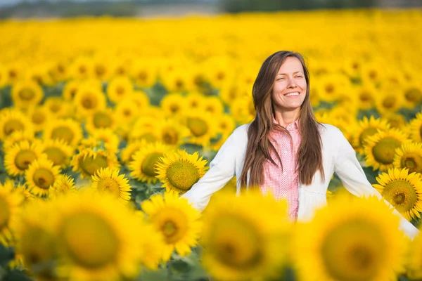 Vacker kvinna i en solros fält — Stockfoto