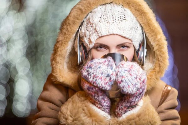 Jonge vrouw met hoofdtelefoon buiten in de winter — Stockfoto