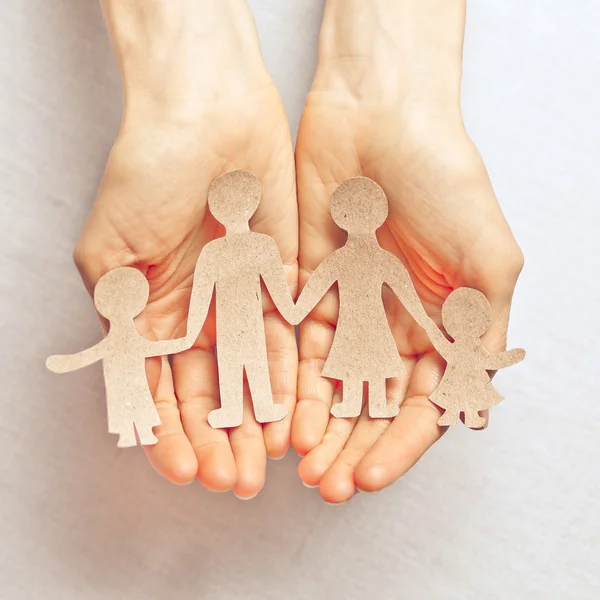 Woman hands showing family of paper men — Stock Photo, Image