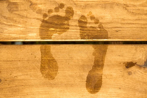 Huellas de un hombre. Rastros de patas descalzas en terraza de madera —  Fotos de Stock