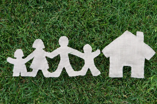 Family from fabric on grass near house — Stock Photo, Image