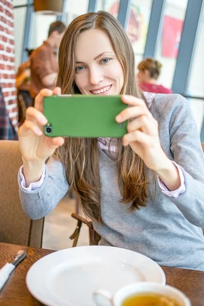 Γυναίκα που χρησιμοποιούν κινητό τηλέφωνο ενώ κάθεται σε ένα καφέ — Φωτογραφία Αρχείου