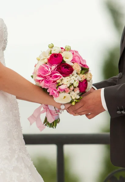 Bruiloft handen met bruids boeket — Stockfoto