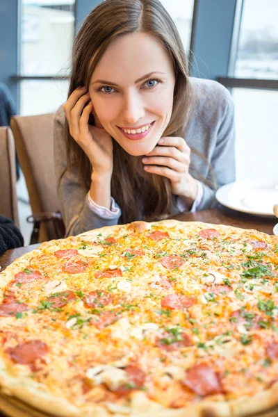 Mladá žena jíst pizzu — Stock fotografie