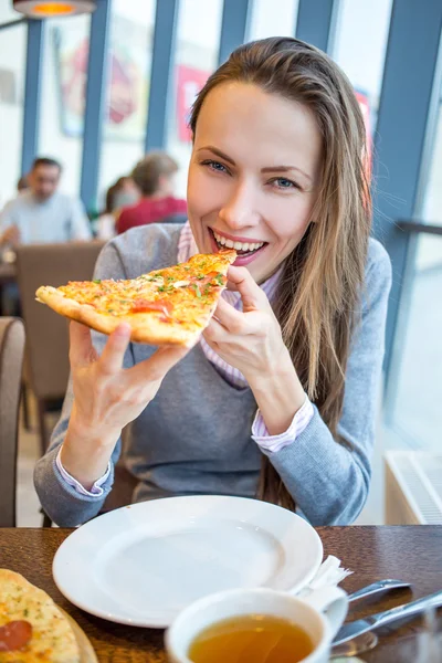 Mladá žena jíst pizzu — Stock fotografie