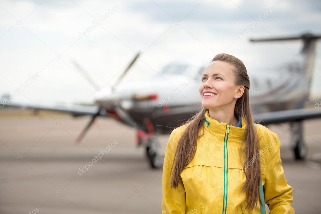 Young woman in front of the airplane
