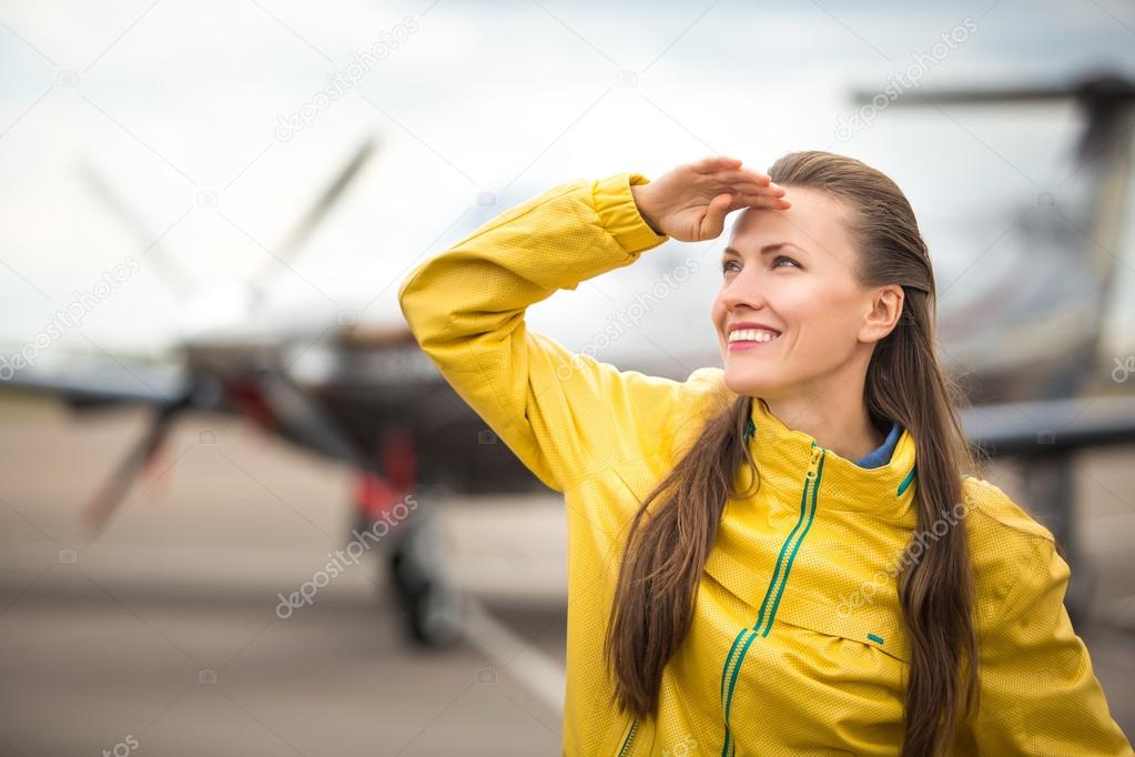 Young woman in front of the airplane