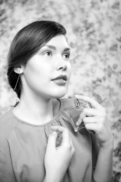 Mulher bonita cheirando seu perfume — Fotografia de Stock