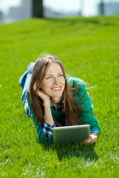 Молодая женщина с помощью планшета на открытом воздухе — стоковое фото