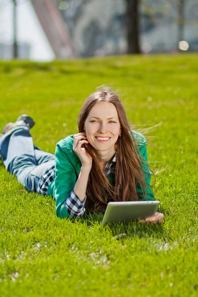 Молодая женщина с помощью планшета на открытом воздухе — стоковое фото
