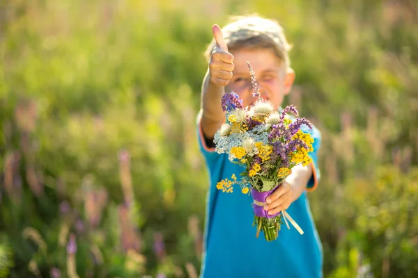 Den lilla pojken med blommor — Stockfoto