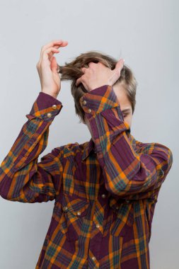 Ekose gömlekli bir gencin duygusal portresi.