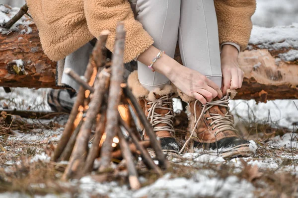 女孩把鞋带绑在雪地的森林里 — 图库照片