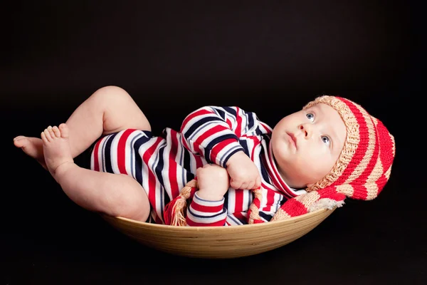 Little boyin a plate on black background — Stock Photo, Image