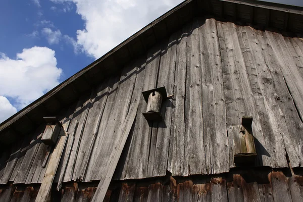 Wooden birdhouse on woodshed — Stock Photo, Image