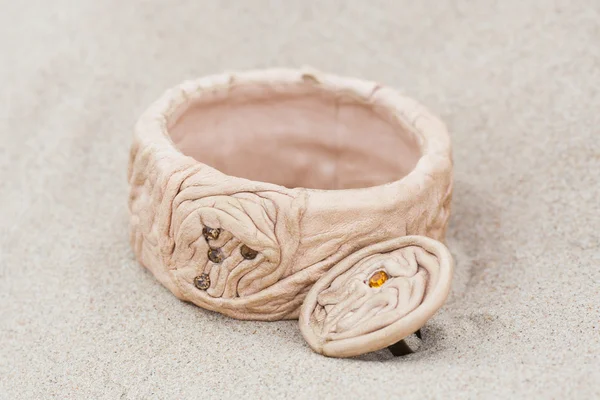 Pulsera hecha a mano con cuero sobre arena — Foto de Stock